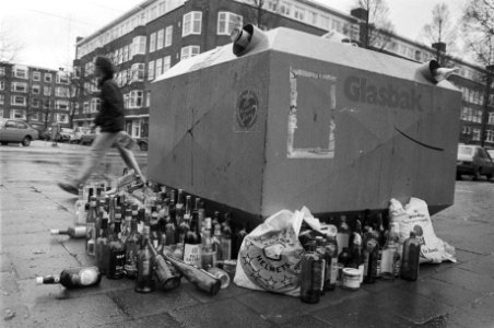 Flessen naast volle glasbak na feestdagen. In Amsterdam vrouw fles naast de voll, Bestanddeelnr 931-8914