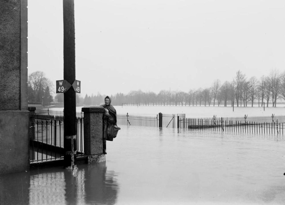 Floods at Builth Wells, Mrs Gwen Ashton standing on a wall holding on to a pillar (1293661)