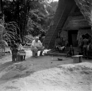 Fotograaf Willem van de Poll in gesprek met bewoners van het boslandcreooldorp i, Bestanddeelnr 252-6833