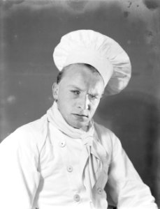 Fotomodel Grummels poseert als kok met koksmuts, Bestanddeelnr 252-1123