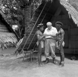 Fotograaf Willem van de Poll geeft boslandcreolen een vuurtje in het boslandcreo, Bestanddeelnr 252-6838