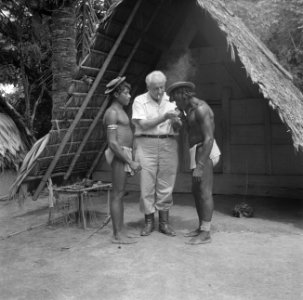 Fotograaf Willem van de Poll geeft boslandcreolen een vuurtje in het boslandcreo, Bestanddeelnr 252-6837