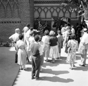 Fotograaf insceneert een foto van een stel voor een groep toekijkers, Bestanddeelnr 254-0751