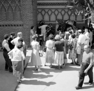Fotograaf insceneert de foto van een stel voor een groep toekijkers, Bestanddeelnr 254-0749