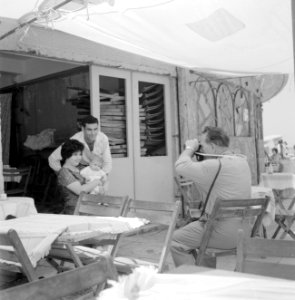 Fotograaf portretteert man, vrouw en baby bij een strandpaviljoen, Bestanddeelnr 255-1967