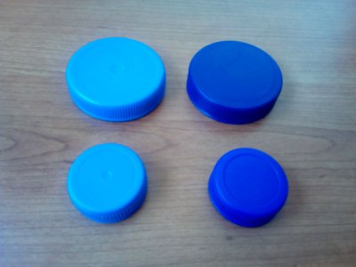 Four blue plastic bottle lids A