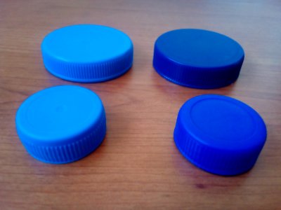 Four blue plastic bottle lids B