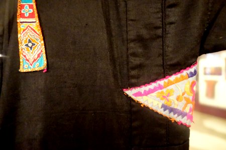 Festive gown detail, Thai Trang, Son La, 1957, view 2, handmade cotton, indigo, embroidered patterns, applique - Vietnamese Women's Museum - Hanoi, Vietnam - DSC03845