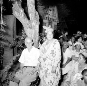 Feestelijk geklede vrouw naast een man op een feest in Paramaribo, Bestanddeelnr 252-2459