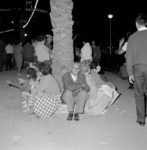 Feestvierders zitten op het randje rondom een boom en rusten uit, terwijl andere, Bestanddeelnr 255-1934 photo