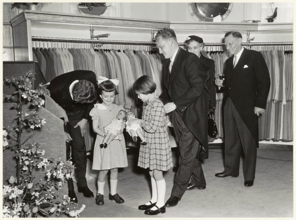 Firma Witteveen opent een modemagazijn in de Grote Houtstraat 25-27. Twee meisjes, Annemieke Traanberg en Ansje Dijkzeu,l krijgen een pop aangeboden., NL-HlmNHA 54011227