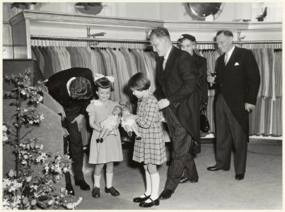 Firma Witteveen opent een modemagazijn in de Grote Houtstraat 25-27. Twee meisjes, Annemieke Traanberg en Ansje Dijkzeu,l krijgen een pop aangeboden., NL-HlmNHA 54011227