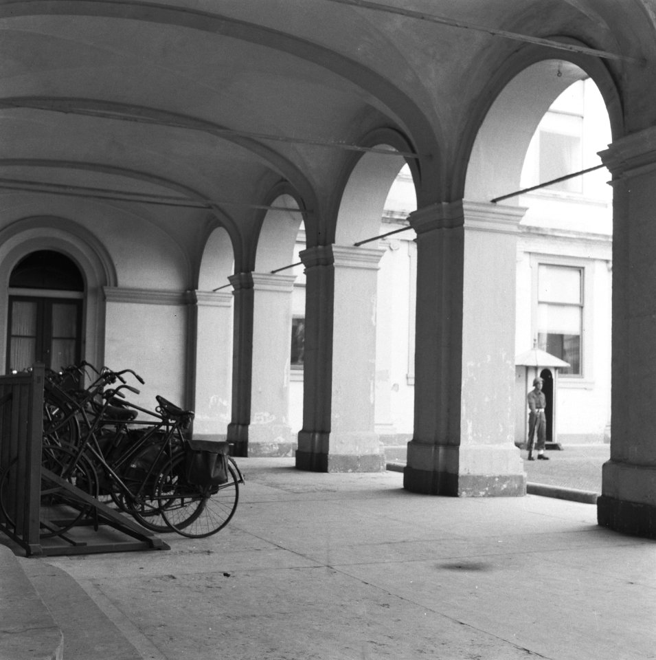 Fietsenrek onder arcade In de achtergrond een wachtpost, Bestanddeelnr 900-7678