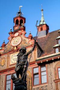 Figur auf dem Neptunbrunnen in Tübingen mit Rathaus im Hintergrund 002