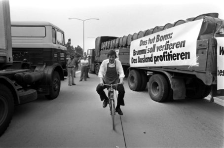Fietser rijdt tussen de vrachtwagens door, Bestanddeelnr 928-0034