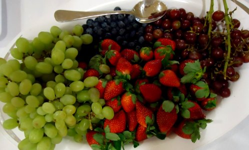 Fruits on a platter including grapes strawberries blueberries photo