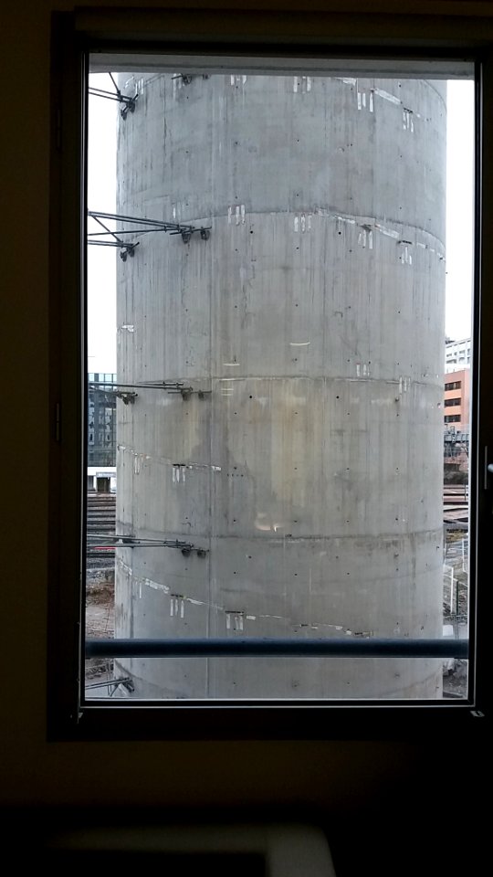 Gare de Lyon-Part-Dieu - Construction du futur parking des voitures de location, pile de la rampe d'accès sud vue à travers une fenêtre des bureaux de la rue de la Villette