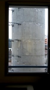 Gare de Lyon-Part-Dieu - Construction du futur parking des voitures de location, pile de la rampe d'accès sud vue à travers une fenêtre des bureaux de la rue de la Villette