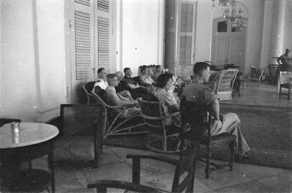 Gasten van kolonel Thomson luisteren, gezeten op de veranda van het paleis, naa…, Bestanddeelnr 112-5-6