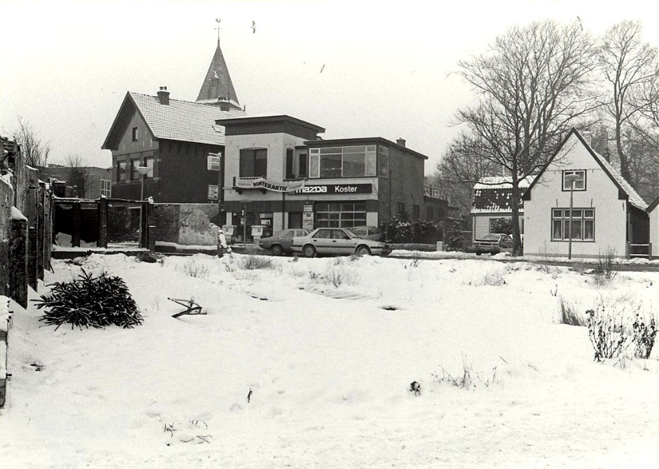Garage Koster aan de Wüstelaan bij de Hoofdstraat, het terrein op de voorgrond waar de Weijmann heeft gestaan. Aangekocht in 1985 van United Photos de Boer bv. - Negatiefnummer 24820 k 33. Gepubliceer