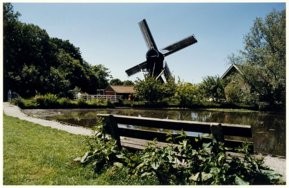 Gezicht op de Schoterveense molen en de vijver in de Schoterveenpolder aan de Heussensstraat. NL-HlmNHA 54028505