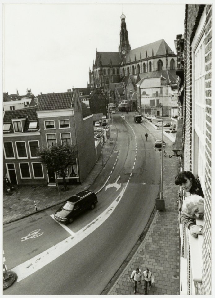Gezicht vanuit de lucht de Damstraat in, ziende naar de Grote kerk en rechts het parkeerterrein dat onstaan is na de sloop van het Enschedé complex. NL-HlmNHA 54035285