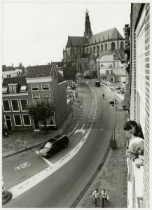 Gezicht vanuit de lucht de Damstraat in, ziende naar de Grote kerk en rechts het parkeerterrein dat onstaan is na de sloop van het Enschedé complex. NL-HlmNHA 54035285