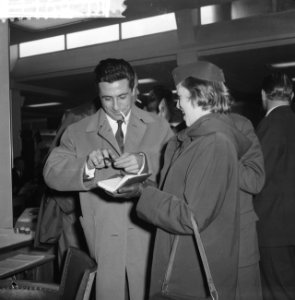 Gilbert Bécaud deelt op Schiphol handtekeningen uit, Bestanddeelnr 911-6920