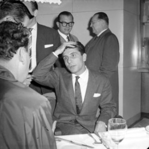 Gilbert Bécaud tijdens een persconferentie op Schiphol, Bestanddeelnr 911-6917