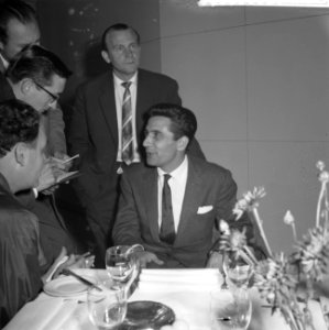 Gilbert Bécaud tijdens een persconferentie op Schiphol, Bestanddeelnr 911-6916