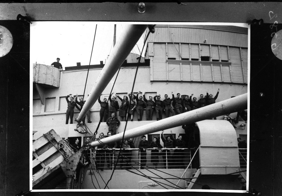 Geuniformeerde mannen en vrouwen zwaaien vanaf een schip naar de wal, Bestanddeelnr 900-6582