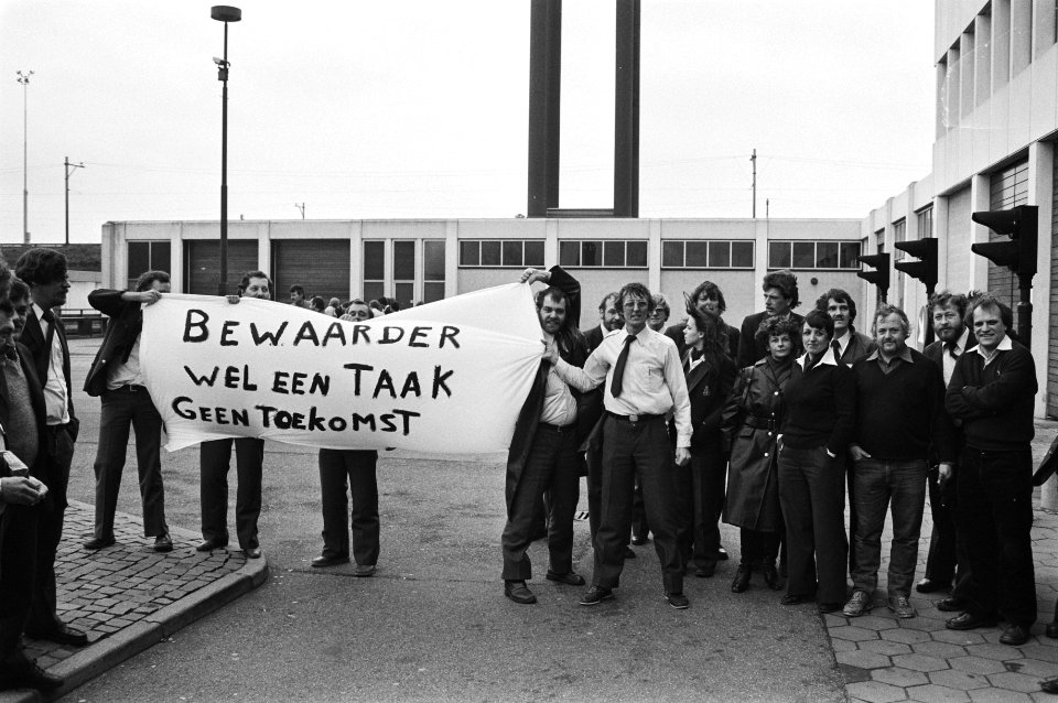 Gevangenbewaarders protesteren bij de ingang met een spandoek met Bewaarder wel, Bestanddeelnr 932-4821