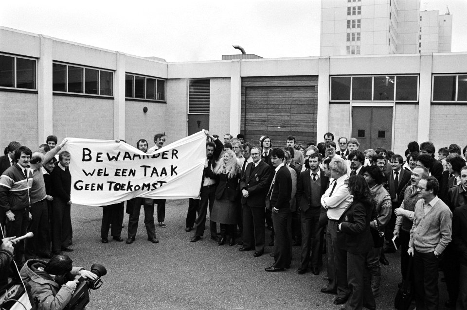 Gevangenbewaarders protesteren bij de ingang met een spandoek met Bewaarder wel, Bestanddeelnr 932-4820