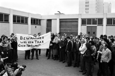 Gevangenbewaarders protesteren bij de ingang met een spandoek met Bewaarder wel, Bestanddeelnr 932-4820