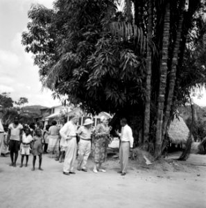 Gezelschap in een dorp in Suriname. Op de rug gezien Hildegard van de Poll, rech, Bestanddeelnr 252-5159
