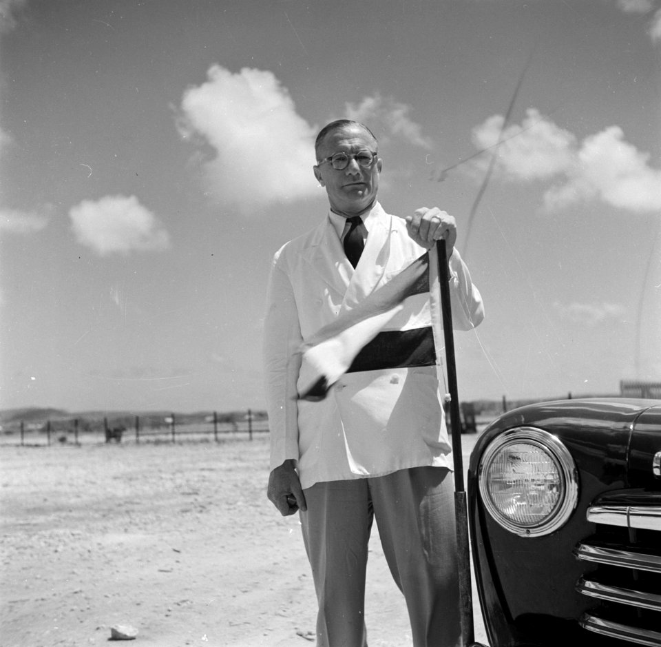 Gezaghebber Xavier Krugers bij de auto waarmee fotograaf Van de Poll van het vli, Bestanddeelnr 252-8329