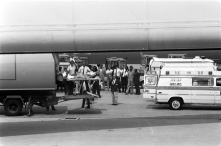 Gewonde wordt op een brancard van het vliegtuig naar een ambulance gebracht, Bestanddeelnr 934-4670