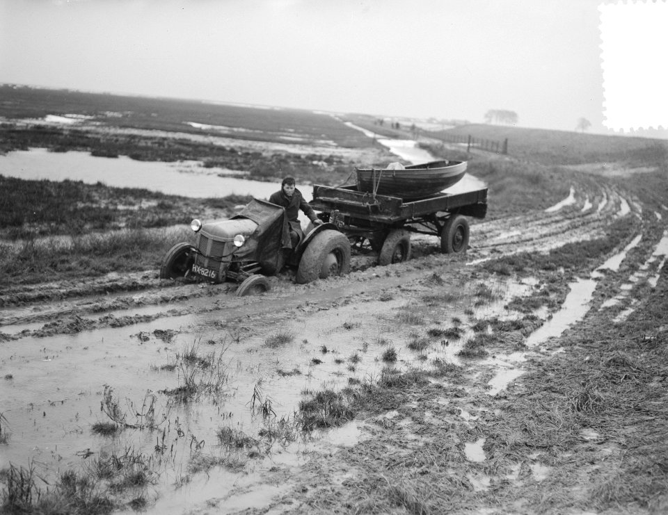 Goeree Overflakkee Sluishaven. Tractor trekt aanhanger door modder, Bestanddeelnr 905-5424