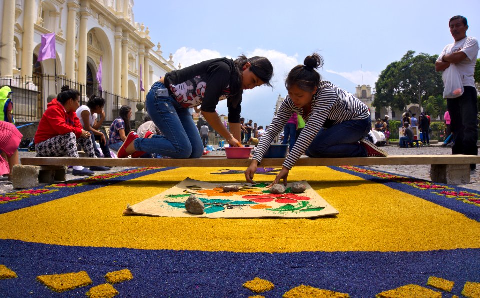 Girls preparing sawdust carpet for Semana Santa in Antigua, Guatemala