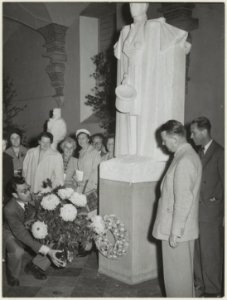 Godfried Bomans legt bloemen bij het beeld van Hildebrand in de Vleeshal. NL-HlmNHA 54010746