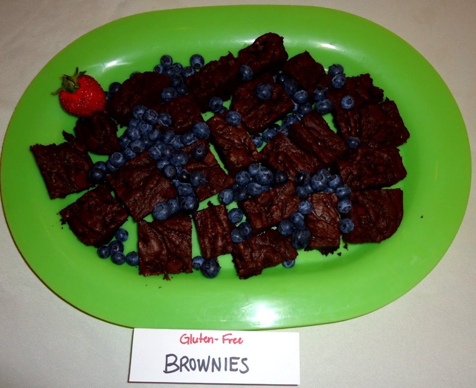 Gluten free brownies and blueberries on a green plate