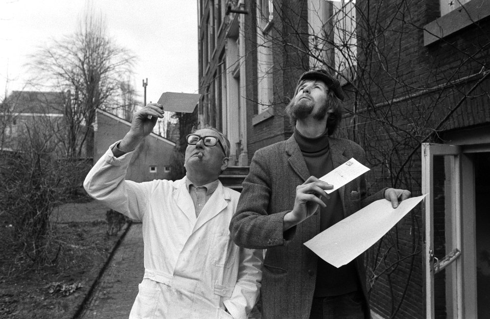 Gedeeltelijke zonsverduistering twee mannen bekijken zon met negatief en papier, Bestanddeelnr 924-3034