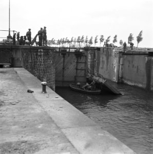 Geallieerde militairen staan bij een vernielde sluis. In het water een bootje m, Bestanddeelnr 901-4650