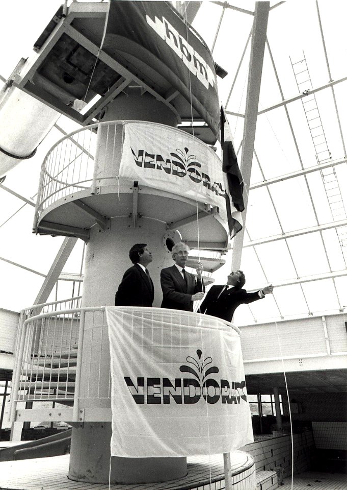 Gedeputeerde G. de Boer hijst de vlag, i.v.m. het hoogste punt van het zwemparadiijs Vendorado. Directeur Mr. Kruijff en Ir. van der Meer van de Hollandse Beton Mij. Aangekocht in 1989 van United Phot
