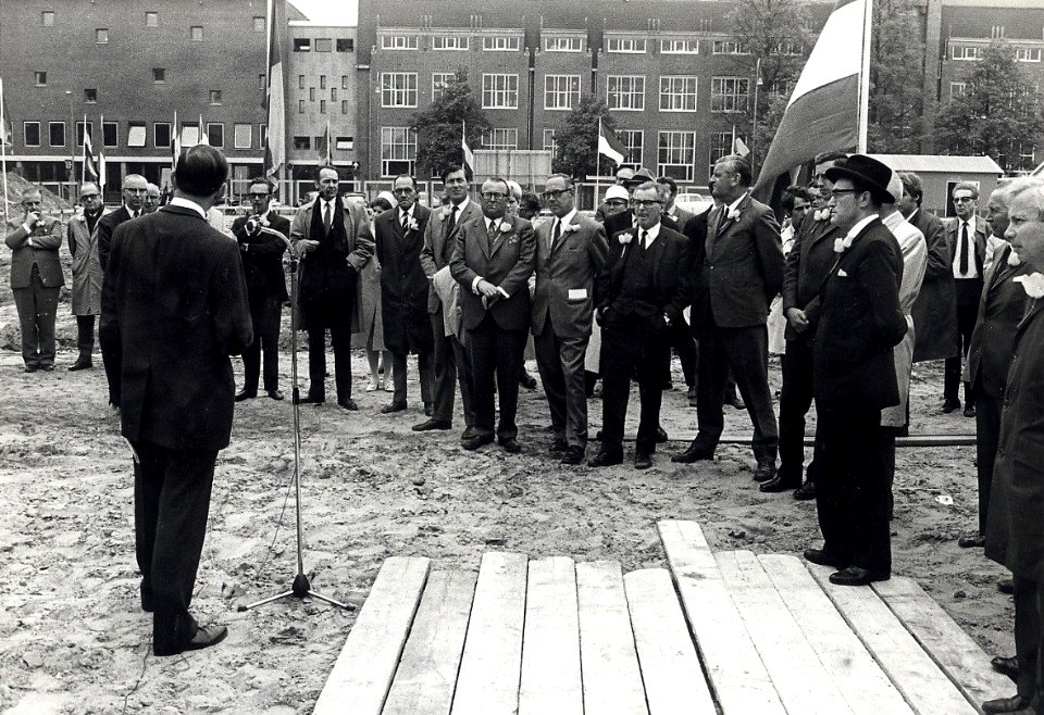Genodigden worden toegesproken, waarna de eerste paal wordt geslagen. Geschonken in 1976 door Dhr. D. Tump te Haarlem. Identificatienummer 54-003985, NL-HlmNHA 54003985