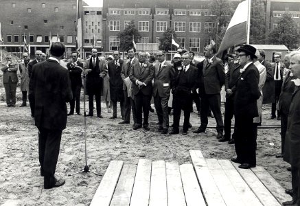 Genodigden worden toegesproken, waarna de eerste paal wordt geslagen. Geschonken in 1976 door Dhr. D. Tump te Haarlem. Identificatienummer 54-003985, NL-HlmNHA 54003985