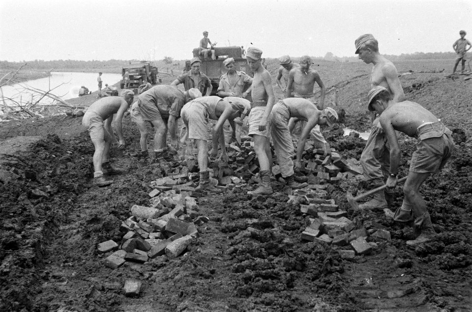 Genisten bezig met het verharden van een weg langs eenkanaal bij Cikampek, Bestanddeelnr 466-5-2