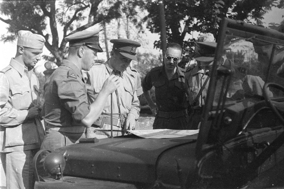Generaal Doorman (midden) bekijkt een kaart die op de jeep is uitgespreid, Bestanddeelnr 56-3-2
