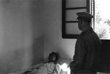 Generaal Kruls in gesprek met een patiënt in een militair hospitaal, Bestanddeelnr 4190