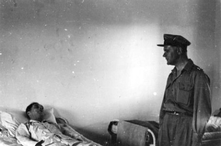 Generaal Kruls in gesprek met een patiënt in een militair hospitaal, Bestanddeelnr 4191